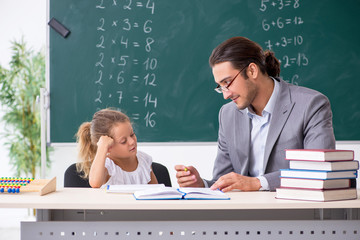 Teacher with young girl in the classroom