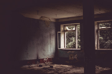 Dark room in an abandoned ruined building. Light from a window