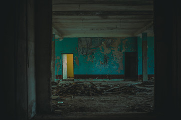 Fototapeta na wymiar Dark room in an abandoned ruined building. Light from a window
