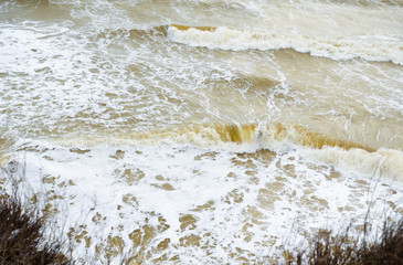 View from a high cliff on the stormy sea and the big waves below. - 329318828