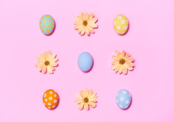 Creative Easter holiday layout eggs colored handmade paint ed with flower on pink background.Seasonal flat lay concept.