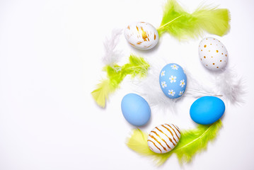 Creative Easter holiday layout eggs colored handmade paint ed with feather on white background.Seasonal flat lay concept.