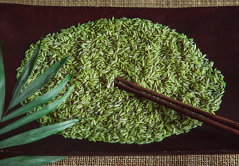 Green rice on wooden plate