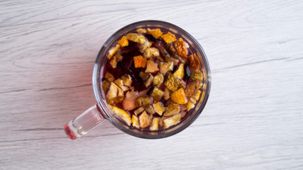 Fragrant fresh hot tea with fruits is poured into a glass mug on a light background. Tasty breakfast. Proper nutrition. Tea party. Top view.