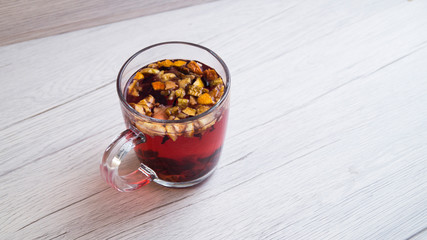 Fragrant fresh hot tea with fruits is poured into a glass mug on a light background. Tasty breakfast. Proper nutrition. Tea party. Copy space.