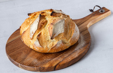 Round Bread Loaf or Boule on wood cutting board. Grey background. isolated. Concept: healthy live. 