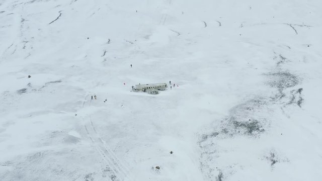 Aerial drone view of Solheimasandur dc3 Plane Crash in a Snowy Landscape in Iceland. Unrecognizable people