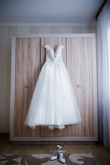 bride wedding dress hanging on the closet