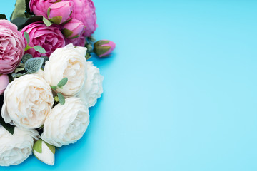 Pink and white flowers on blue background. Mother’s Day, Spring concept. Greeting, invitation card. Top view style with copy space for your text.