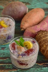 Bubur Cha Cha, Malay dessert made from tapioca pearls, sweet potato, taro, yam, banana, black eyed peas and coconut milk. Garnish with pandan leaf