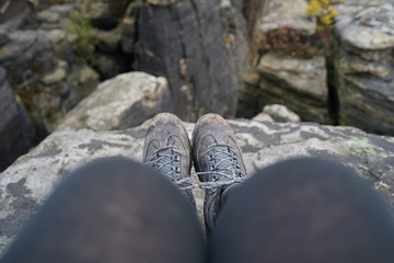 Hiking boots, shoe selfie at sandstone cliff looking into the abyss   