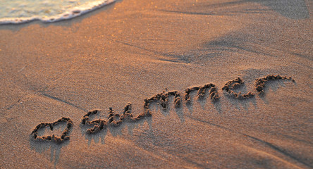 Fototapeta na wymiar Summer written on sand.