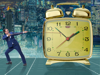 Businessman pulling clock in time management concept