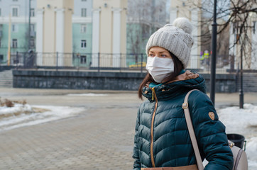 Traveler european woman wears medical mask to protect against coronavirus or flu in the Park. Prevention in public spaces.