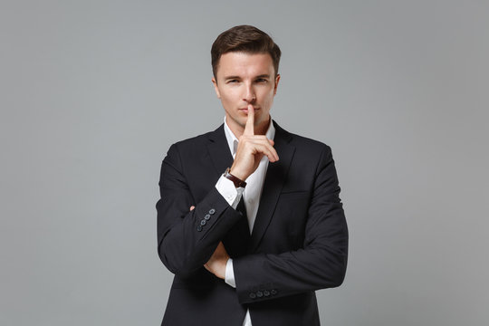 Secret Young Business Man In Classic Suit Shirt Posing Isolated On Grey Background. Achievement Career Wealth Business Concept. Mock Up Copy Space. Say Hush Be Quiet With Finger On Lips Shhh Gesture.