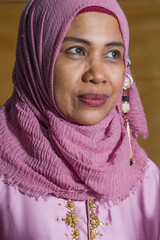 happy and positive senior muslim woman in her 50s wearing Islam hijab head scarf and traditional...