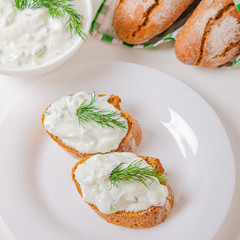 Greek appetizer (salad) - tzatziki. Yogurt, fresh cucumbers and dark (buckwheat) bread (baguette).