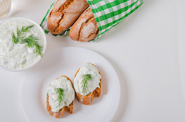 Greek appetizer (salad) - tzatziki. Yogurt, fresh cucumbers and dark (buckwheat) bread (baguette).
