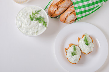 Greek appetizer (salad) - tzatziki. Yogurt, fresh cucumbers and dark (buckwheat) bread (baguette).