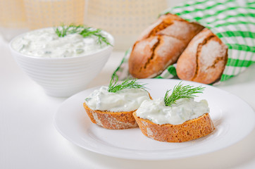 Greek appetizer (salad) - tzatziki. Yogurt, fresh cucumbers and dark (buckwheat) bread (baguette).