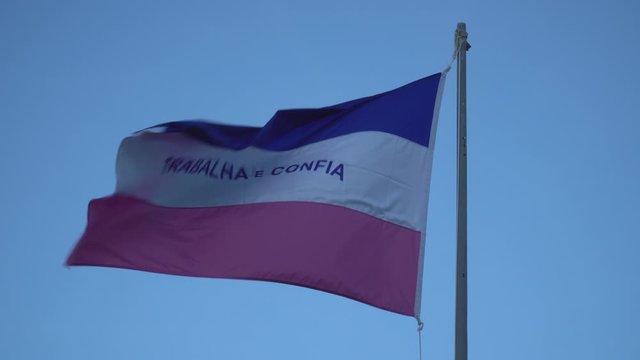 Beautiful flag of Espirito Santo state waving in the wind on sunny summer day with blue sky. Concept of state, symbol, republic, Brazil, cultural identity, democracy, geography and politics.