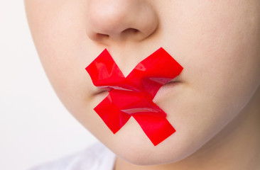 Domestic violence and child protection, concept. Child with mouth sealed with red duct tape. 