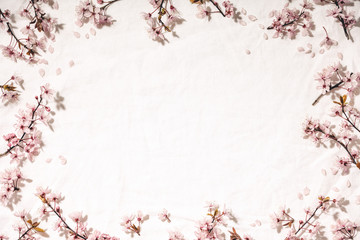 Spring border with cherry blossoms on white linen napkin