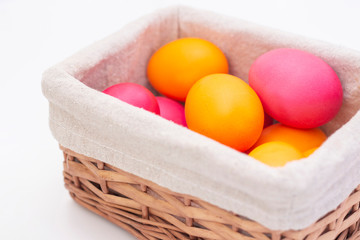Easter eggs in a wicker basket. Happy easter. painted eggs on a light background.