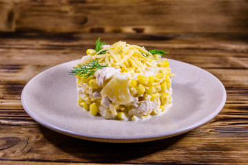 Festive salad with chicken breast, canned pineapple, cheese, sweet corn and mayonnaise on wooden table
