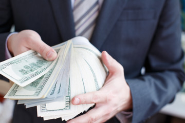 Businessman in suit, tie holds in hands drop of black oil of Brent brand in crystal cube.Pack of...