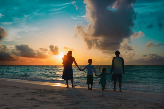 happy family with kids walk at sunset beach