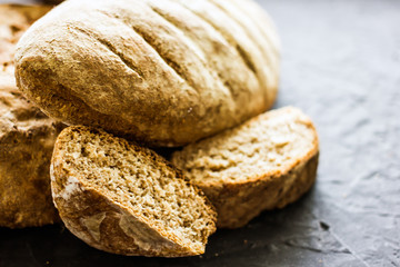Assorted homemade bread close-up. Several loaves of bread on a dark table. The concept of home baking and bread production. Background about bread