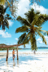 Praslin Seychelles,young men on tropical beach with palm tree, white beach man walking Seychelles...