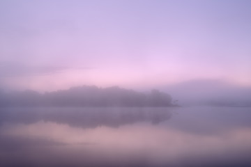 Spring landscape at dawn of the shoreline of Whitford Lake with reflections in calm water, Fort Custer State Park, Michigan, USA