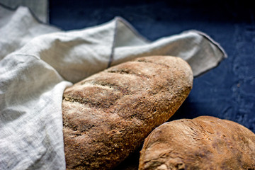 Assorted homemade bread close-up. Several loaves of bread on a dark table. The concept of home baking and bread production. Background about bread