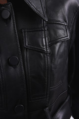 Black leather shirt with crooked stitched pocket. Fashionable clothes. Vertical photo.