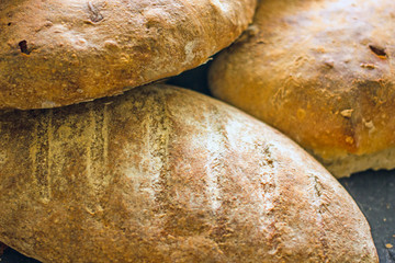 Assorted homemade bread close-up. Several loaves of bread on a dark table. The concept of home...