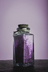 fancy bottle with lavender purple bath salts for relaxing spa treatments with white background