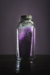 fancy bottle with lavender purple bath salts for relaxing spa treatments with white background