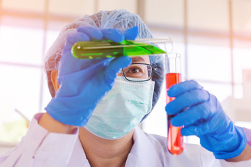Obraz na płótnie Canvas An Asian female scientist is researching a chemical formula in a lab.