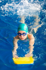 Fototapeta na wymiar Cute little girl swimmer training in a swimming pool