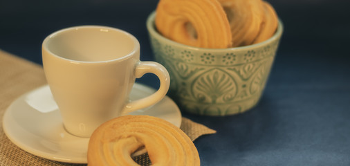 Coffee with butter cookies on dark background