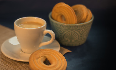 Coffee with butter cookies on dark background