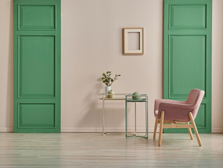 Fototapeta na wymiar Decorative pink chair and green door style with frame and coffee table. pink wall background.