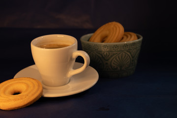 Coffee with butter cookies on dark background