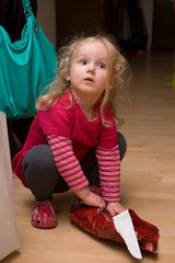 Kleines Mädchen mit blonden Locken packt ein Geschenk aus