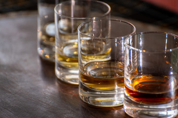 Tasting of flight of Scotch whisky from tumbler glasses in old Edinburgh pub,  Scotland, UK