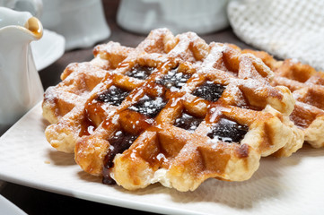 Tasty Belgian dessert, Brussels waffles with syrup and white sugar powder