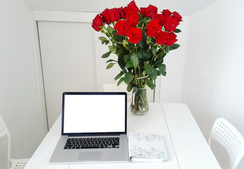 Flowers with a laptop close-up in the workplace.
