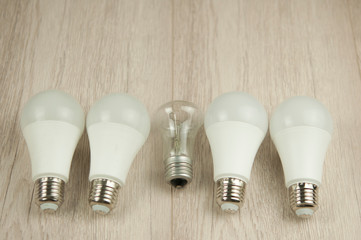 glowing bulb uniqueness concept on white wooden background. Top view